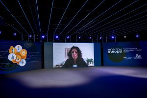 Na zdjęciu ekrany tv z moderatorką sesji na temat partnerstw