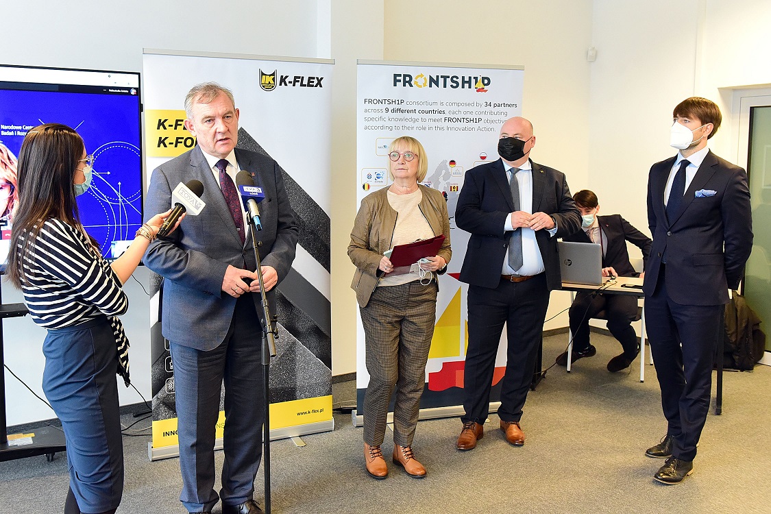 Dziennikarka podstawia mikrofon rektorowi Politechniki Łódzkiej. Obok stoją trzy osoby