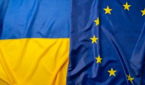 Po lewej niebiesko-żółta flaga Ukrainy, po prawej granatowa flaga Unii Europejskiej z żółtymi gwiazdkami