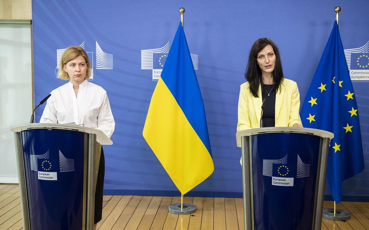 Komisarz Gabriel w żółtym żakiecie i wicepremier Stefaniszyna na konferencji prasowej. W tle niebiesko-żółta ukraińska flaga