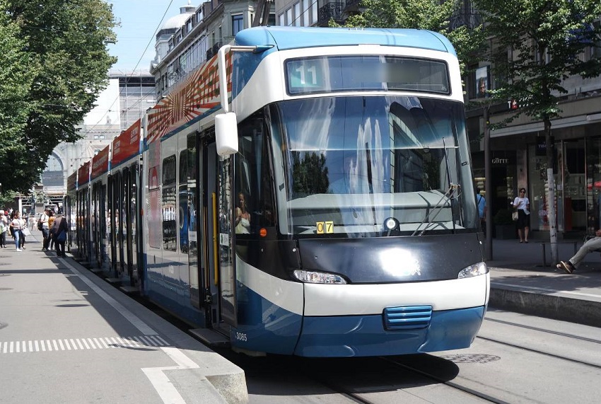 Biało niebieski tramwaj stojcy na przystanku w centrum miasta