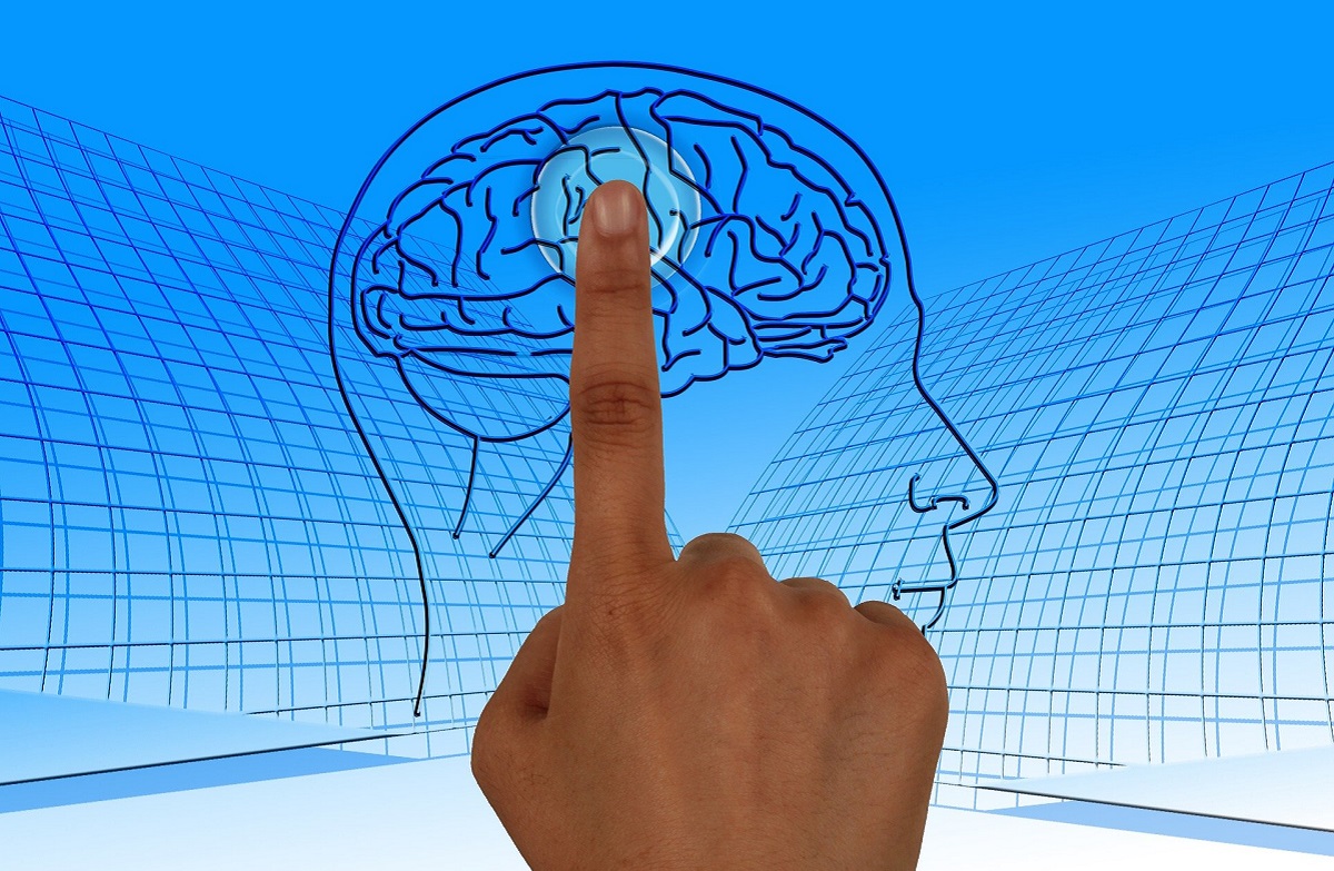 W tle szkic ludzkiej głowy i mózgu. Na pierwszym planie palec wskazujący skierowany na mózg